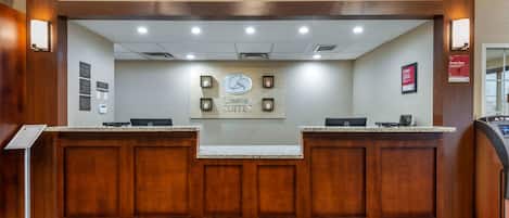 A reception area with a sign for 'Comfort Suites' and a cash register.
