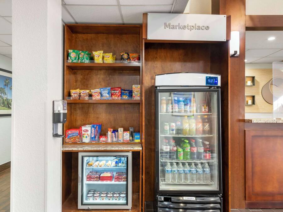 Un quiosco de autoservicio con una sección refrigerada y un congelador, lleno de aperitivos y bebidas.