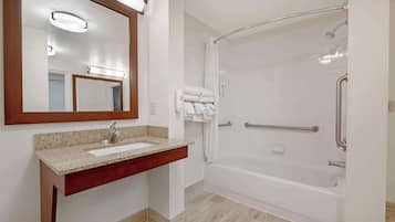 A bathroom with a sink, mirror, and walk-in shower.