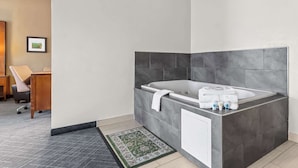 A modern bathroom with a freestanding bathtub, a small sink, and a towel rack.