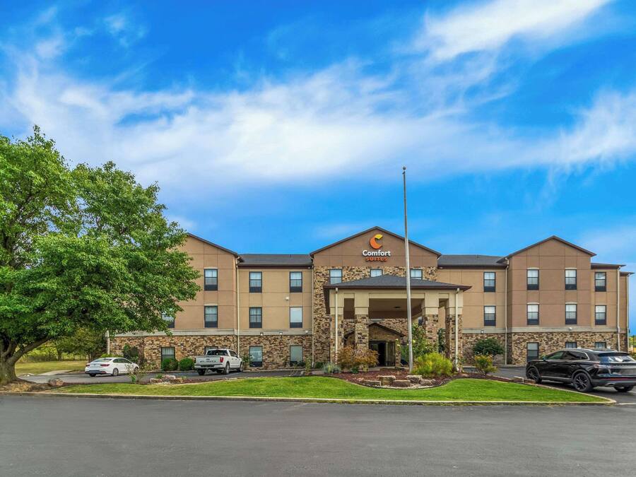 A Comfort Suites hotel with a stone facade, multiple windows, and a covered entrance.