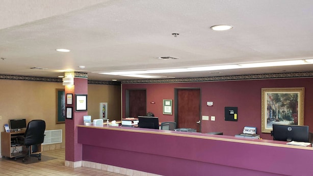 A reception desk with a purple counter, a computer, and a telephone.