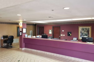 A reception desk with a purple counter, a computer, and a telephone.