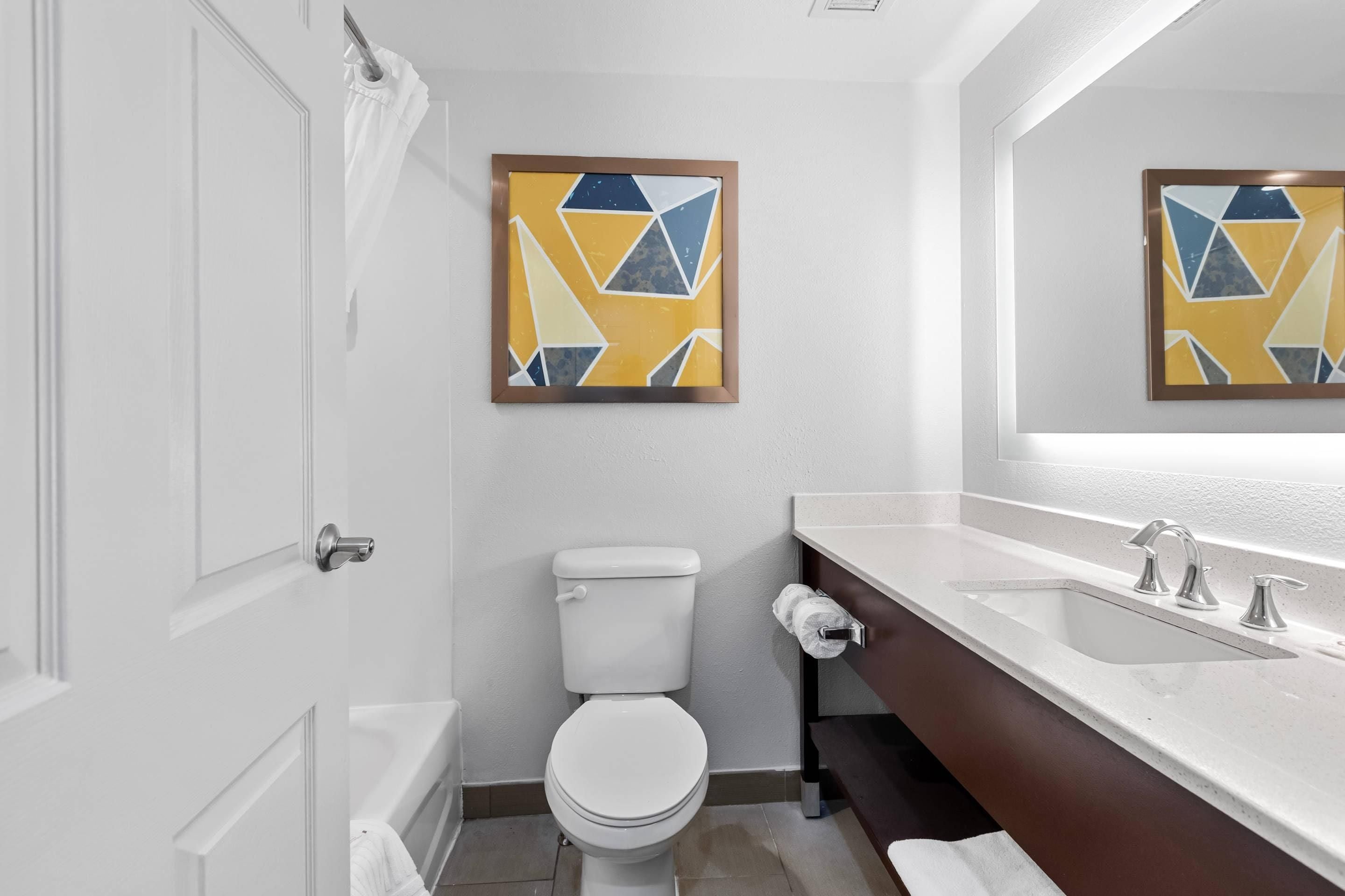 Une salle de bain avec des toilettes, un lavabo et un miroir.