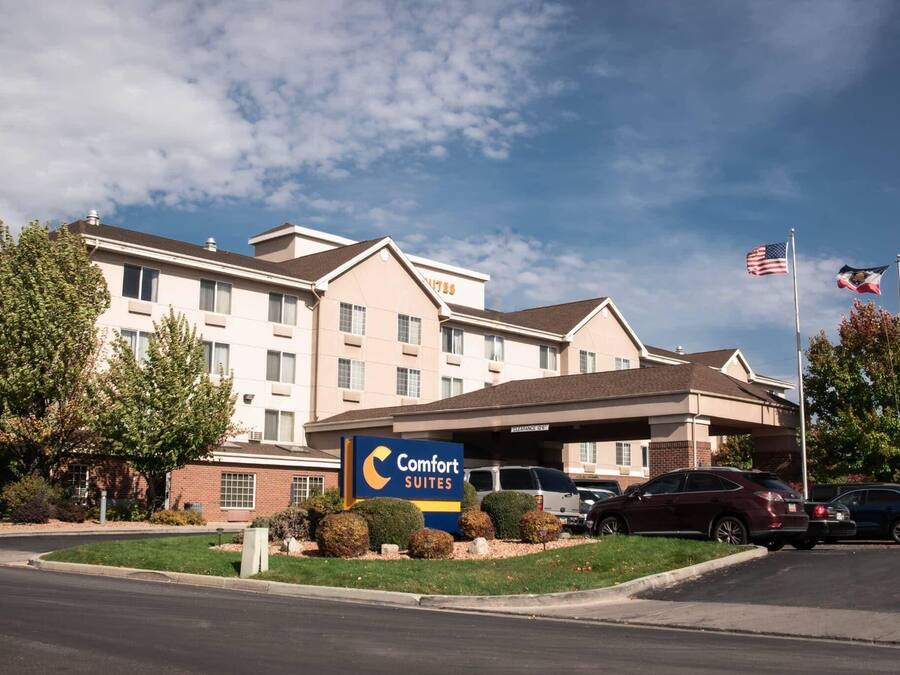 Un hotel Comfort Suites con estacionamiento y cielo despejado.