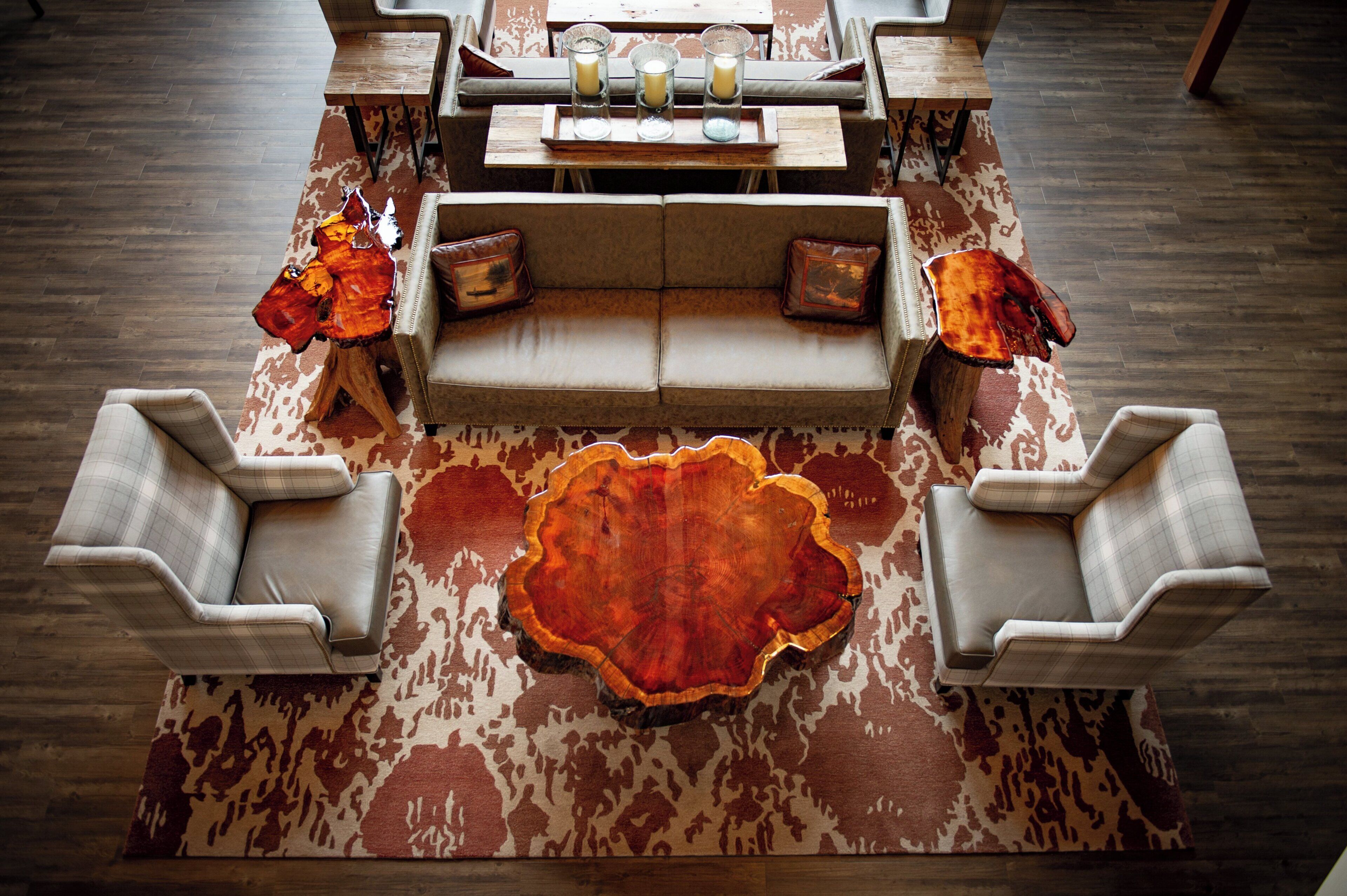 A modern living room with a central sofa, two armchairs, a coffee table, and a decorative rug.