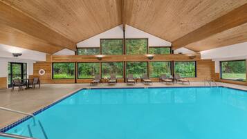 Una piscina techada, sillones reclinables de piscina