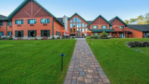 A large, multi-story building with a brick facade and green roof, featuring a central entrance with a covered walkway. - Holiday Inn Express & Suites Hayward by IHG (Hayward)