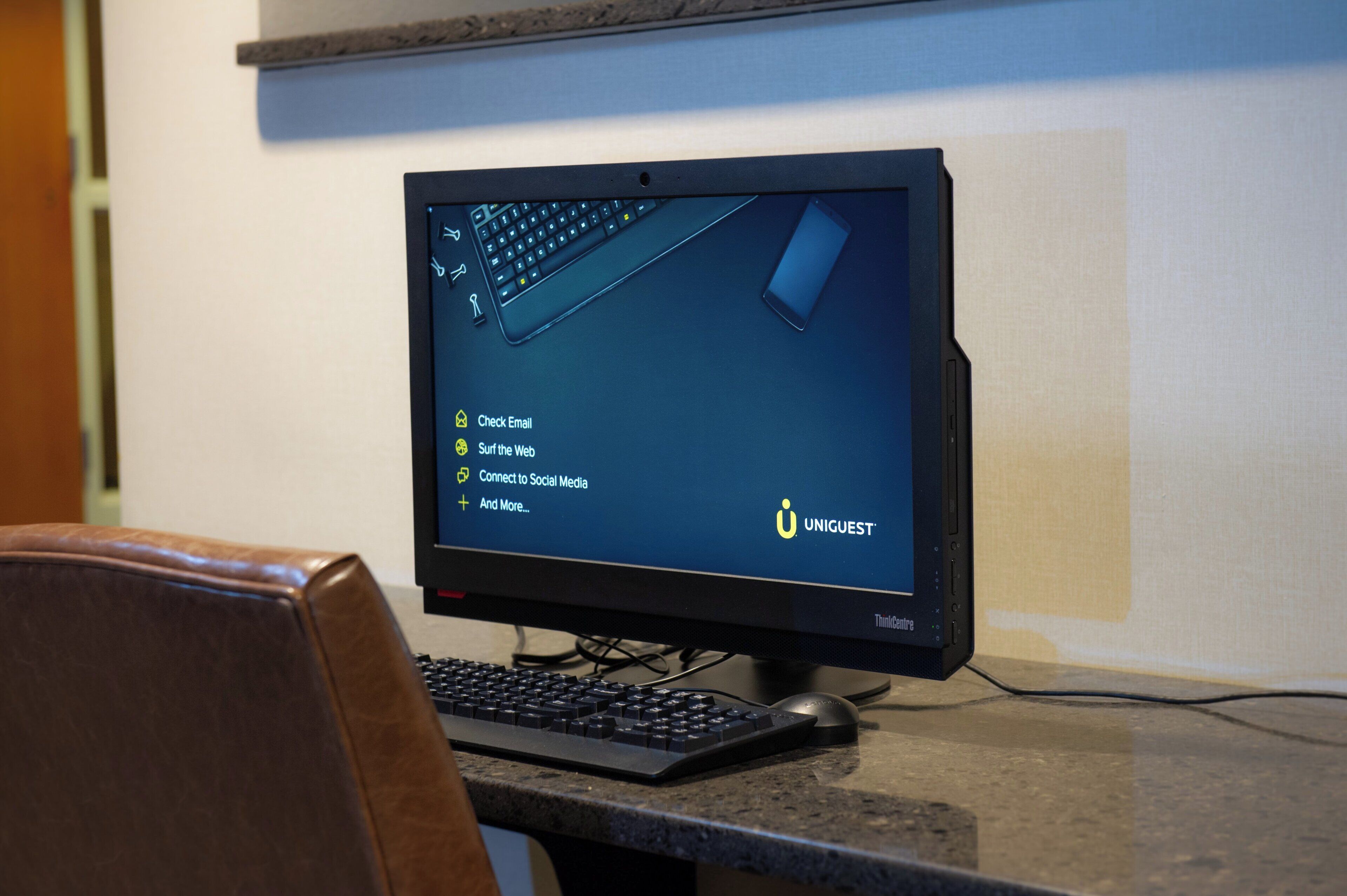 Ein schwarzer Computerbildschirm auf einem Schreibtisch mit Tastatur und Maus, der einen Desktop mit Symbolen für E-Mail, Surfen im Internet, soziale Medien und mehr anzeigt.