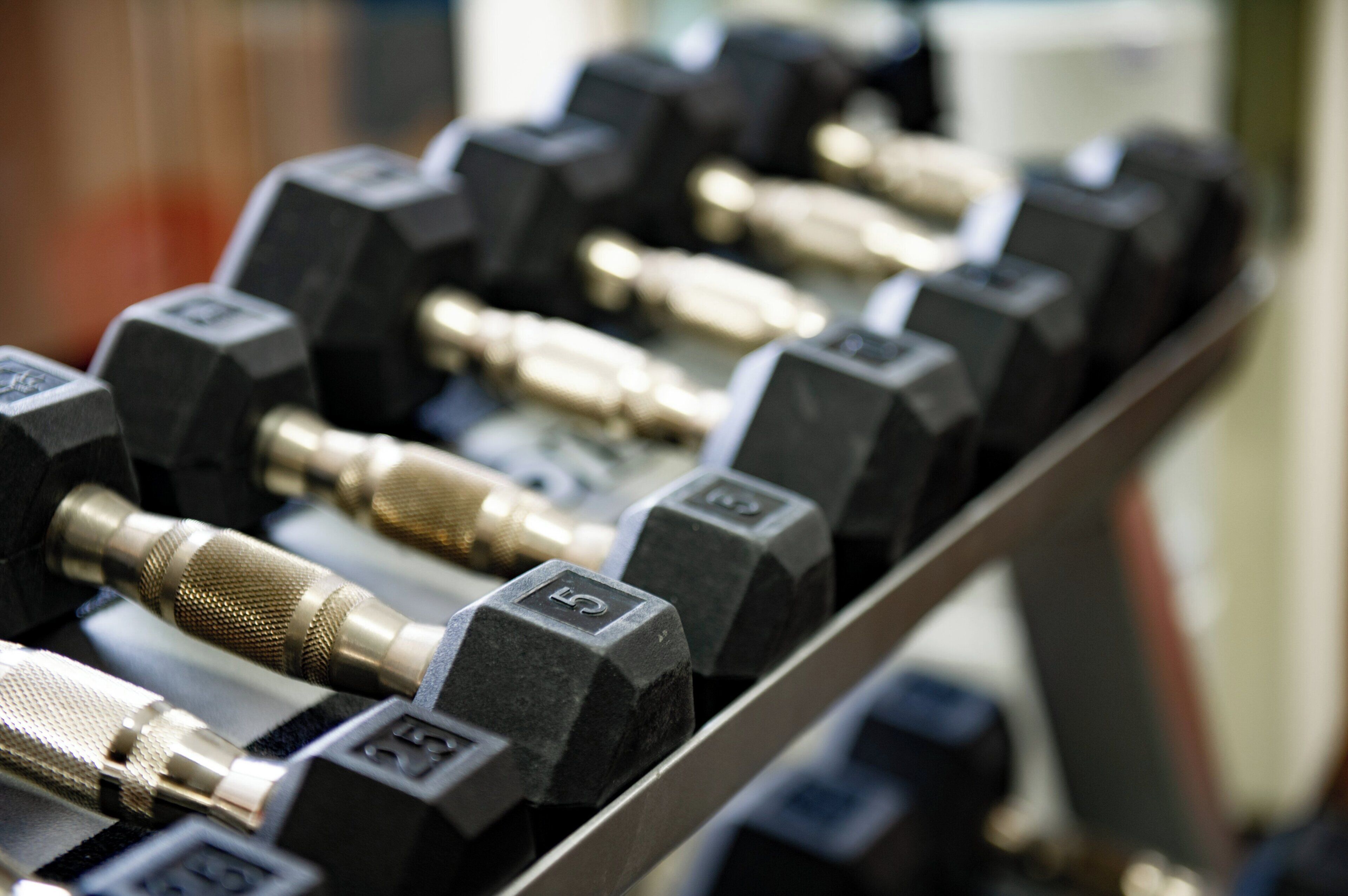 A rack of dumbbells with weights marked on them.