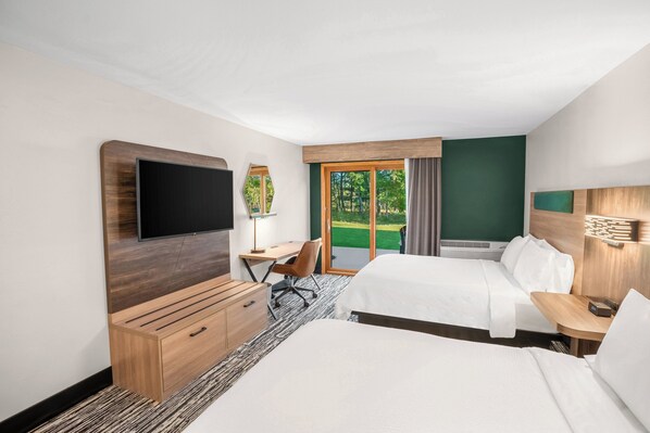 A hotel room with two beds, a desk, a chair, a TV, and a window with a view of greenery. - Holiday Inn Express & Suites Hayward by IHG (Hayward)