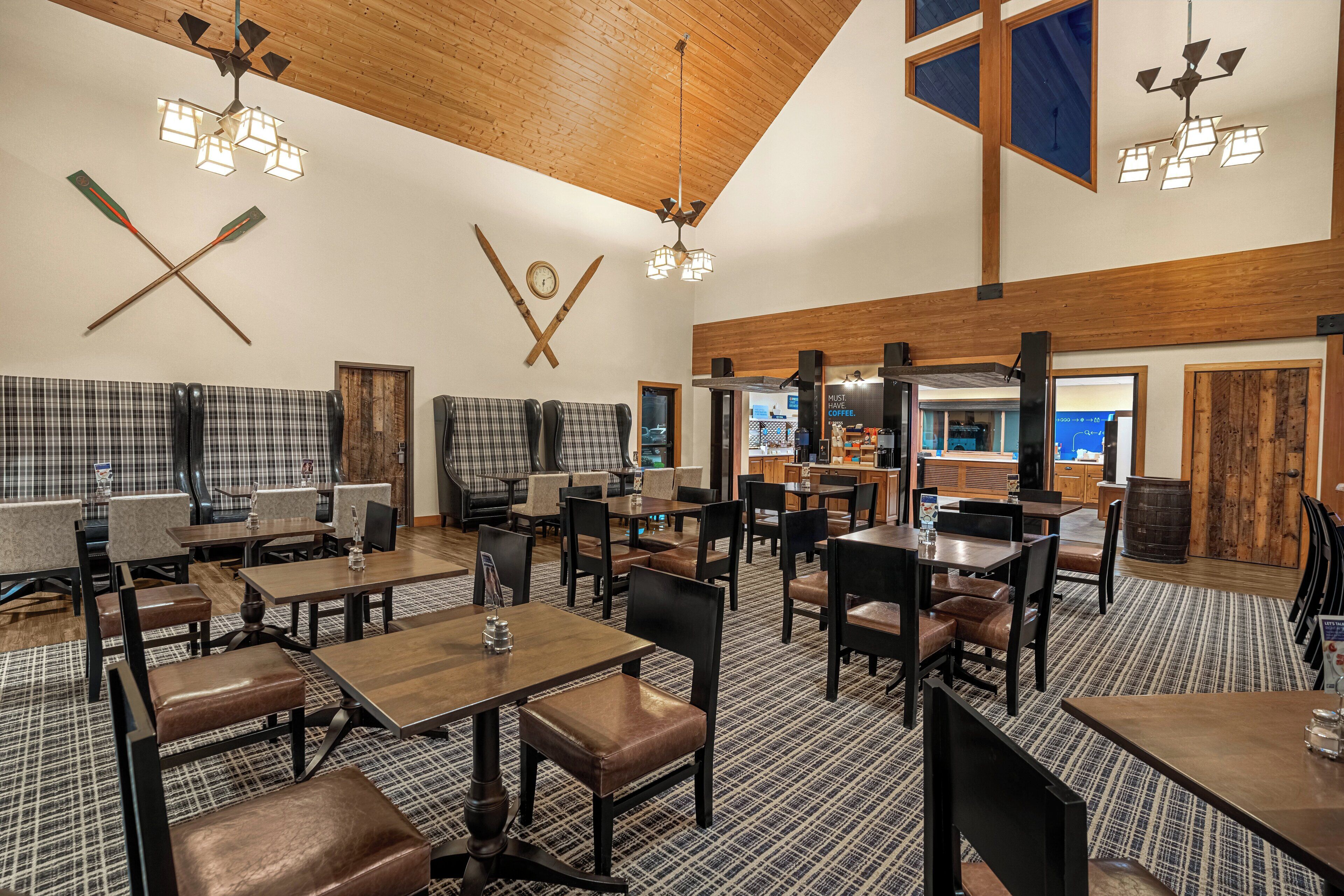 Un restaurante con techo de madera, decoración en la pared con forma de cruz y alfombra estampada.