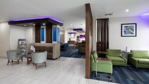 A hotel lobby with a reception desk, seating area, and a bar. - Holiday Inn Express & Suites Chicago West - St Charles by IHG (St. Charles)