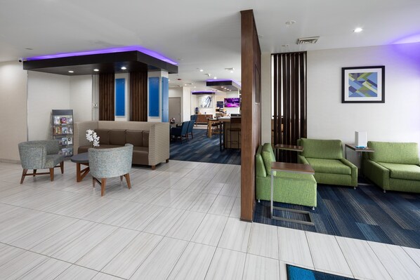 A hotel lobby with a reception desk, seating area, and a bar. - Holiday Inn Express & Suites Chicago West - St Charles by IHG (St. Charles)