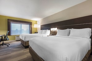 A hotel room with two beds, a desk, and a chair.