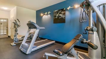 A gym with treadmills, a bench press, and weight machines.