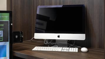 Una computadora de escritorio con teclado y ratón sobre un escritorio de madera.