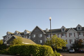 Country Inn & Suites offers a classic, symmetrical facade with a central entrance and balconies.