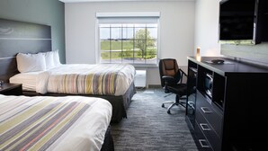 A hotel room with two beds, a desk, a chair, a TV, and a window with a view of a green landscape. - Country Inn & Suites by Radisson, Columbus West, OH (Columbus)