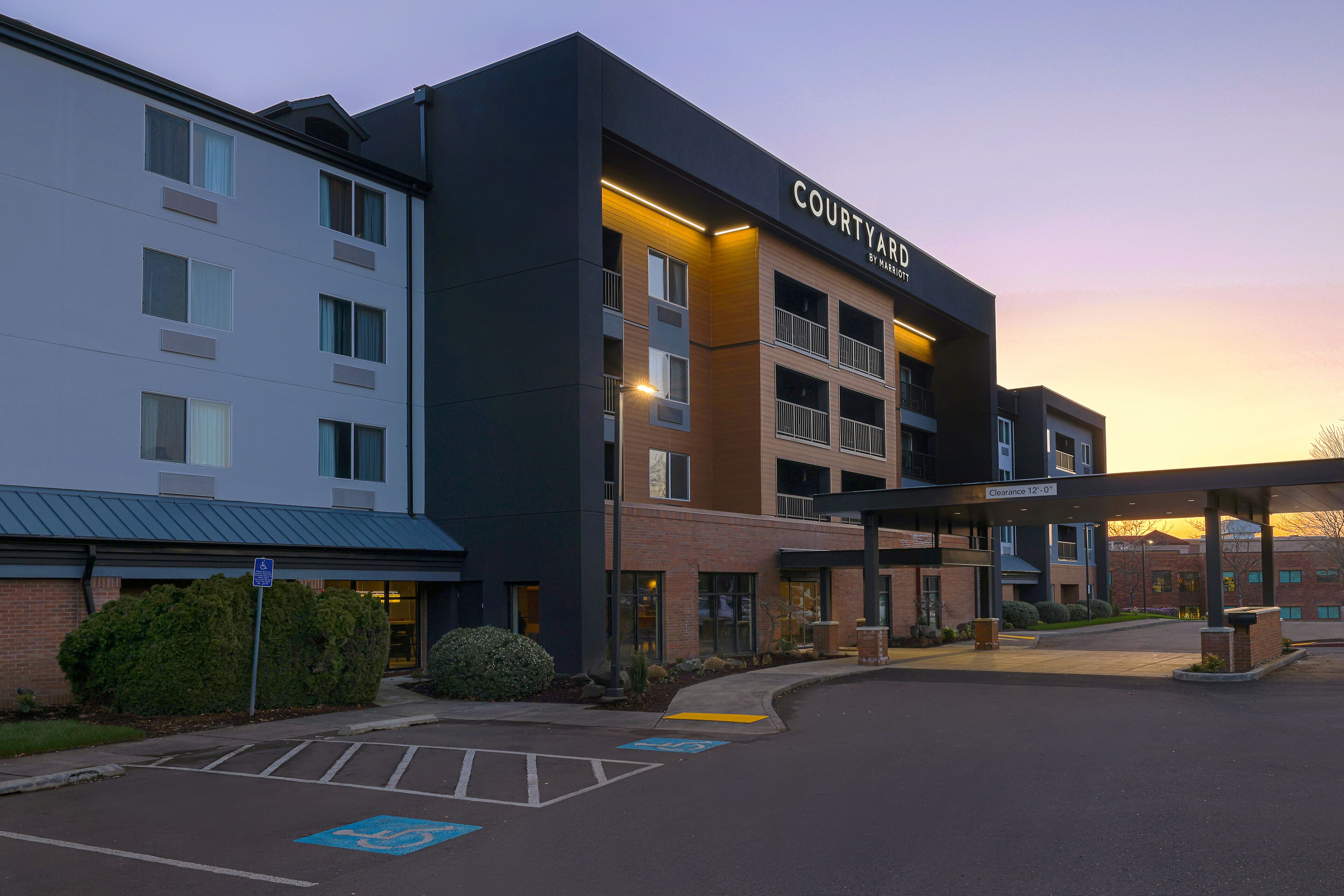 Hotel Courtyard con diseño moderno, que cuenta con una entrada cubierta y un estacionamiento con acceso para personas con discapacidad.