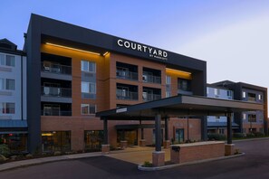 Un hôtel Courtyard by Marriott au design moderne, doté de nombreux balcons et d’un espace d’entrée abrité.