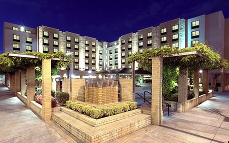 A modern hotel with a central courtyard, multiple floors, and a brick facade.