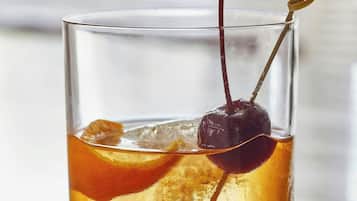 Un verre avec une cerise et une paille.