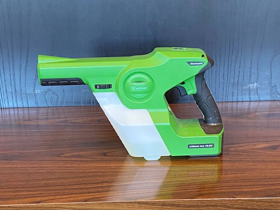 A green and white electric tool on a wooden surface.