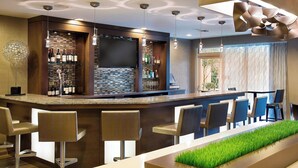 A modern bar area with a counter, bar stools, and a large screen. - Courtyard by Marriott North Seattle/Lynnwood (Lynnwood)
