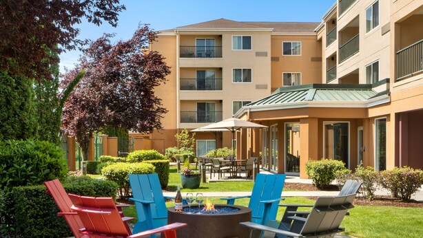 An outdoor seating area with fire pit, chairs, and tables. - Courtyard by Marriott North Seattle/Lynnwood (Lynnwood)