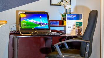 A desk with a laptop, a chair, and a small desk lamp.