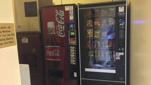 Due distributori automatici, uno con il logo Coca-Cola e l'altro con diverse merendine.
