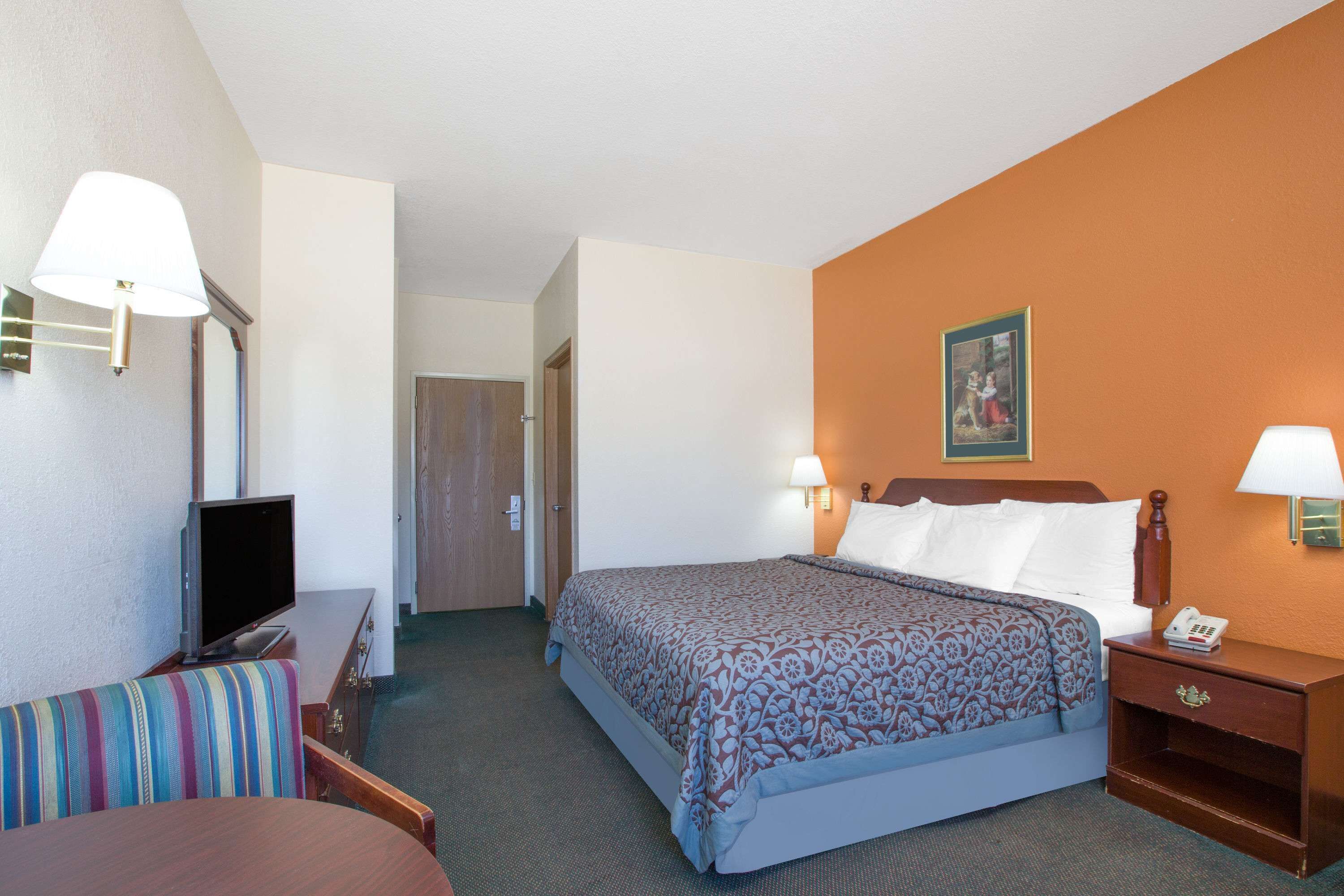 Une chambre d’hôtel équipée d’un lit, d’une télévision, d’un bureau et d’une chaise.