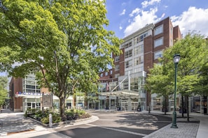 A hotel entrance with a brick facade, a glass entrance, and a flag.