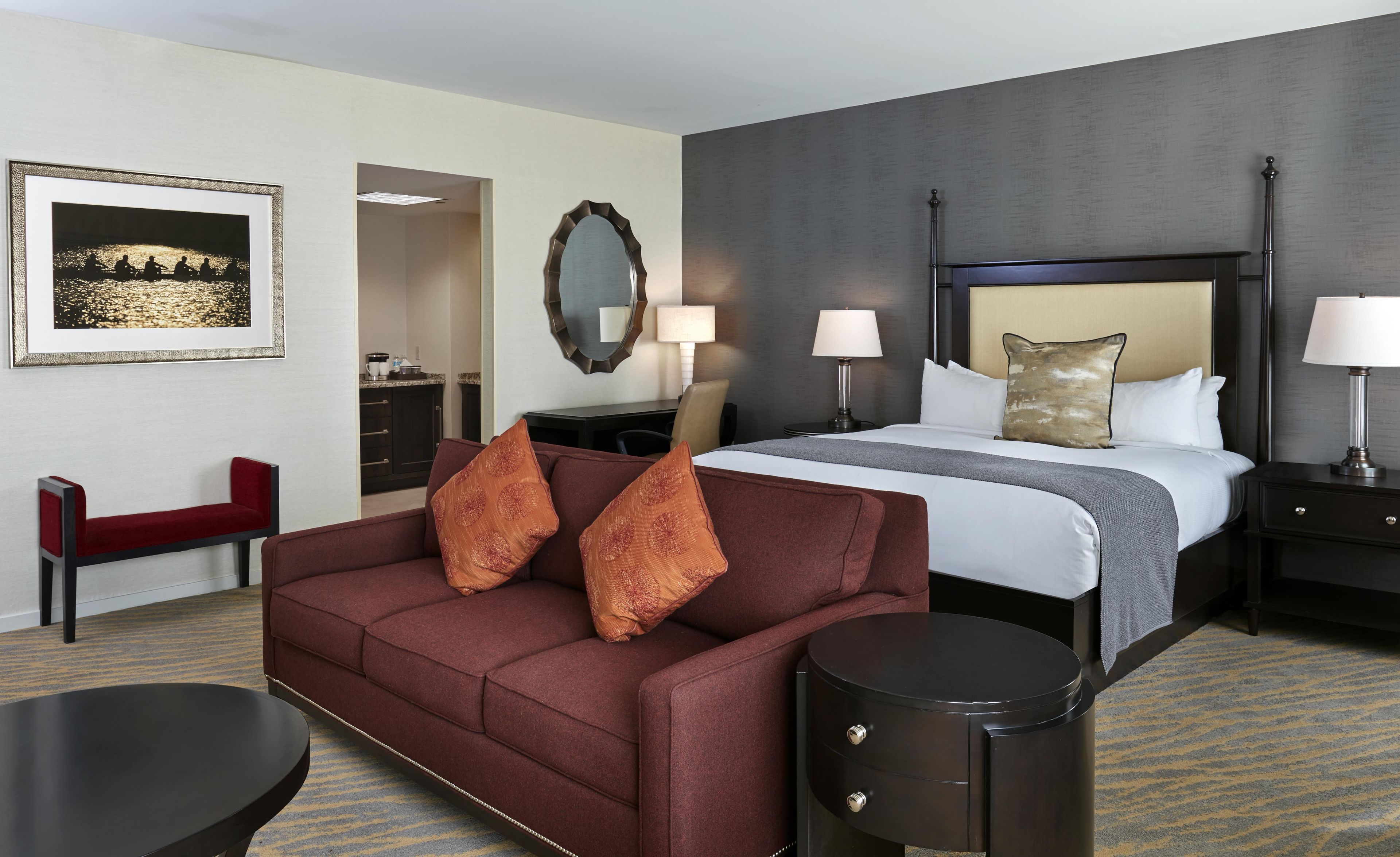 Une chambre d’hôtel comprenant un lit, un canapé, un bureau, une chaise et un coin repas.