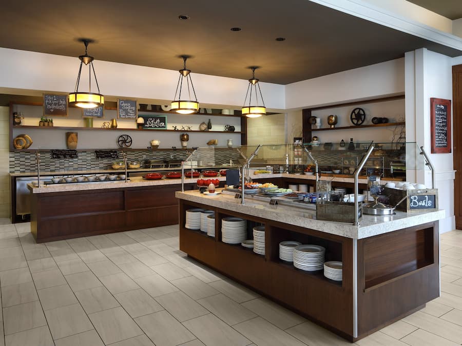 A buffet setup with various food items and a sign indicating 'Breakfast'.