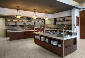 A buffet setup with various food items and a sign indicating 'Breakfast'.