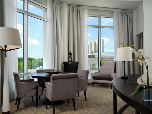 Ett hotellrum med en matplats, en staty och utsikt över stadsbilden.