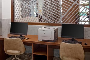 Un espacio de trabajo con dos monitores, una impresora y dos sillas.