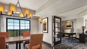 Une chambre d’hôtel dotée d’un coin repas, d’un bureau et offrant une vue sur l’extérieur.