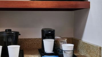 A kitchenette with a microwave, coffee maker, and a dishwasher.