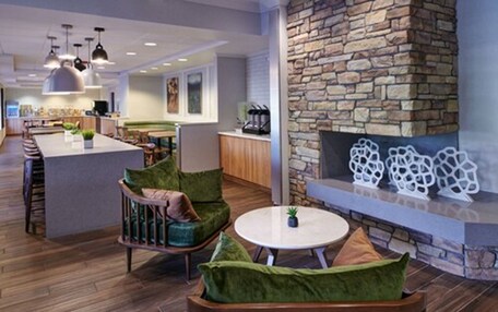 A modern interior with a stone fireplace, wooden furniture, and pendant lighting.