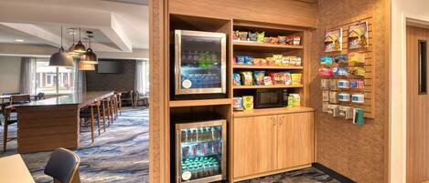 Hotelkamer met kitchenette, koelkast, magnetron en een snackbar met diverse soorten eten.