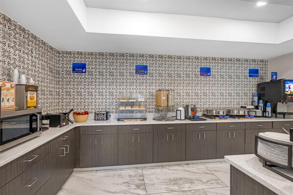 Una cocina moderna con un salpicadero estampado, una estación de café y un microondas.