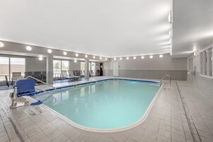 Una piscina techada, sillones reclinables de piscina