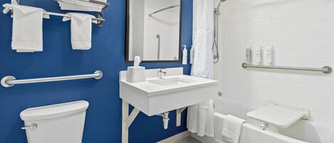 Ein modernes Badezimmer mit blauer Wand, weißen Armaturen, Toilette, Waschbecken, Badewanne, Dusche und einem Handtuchhalter.
