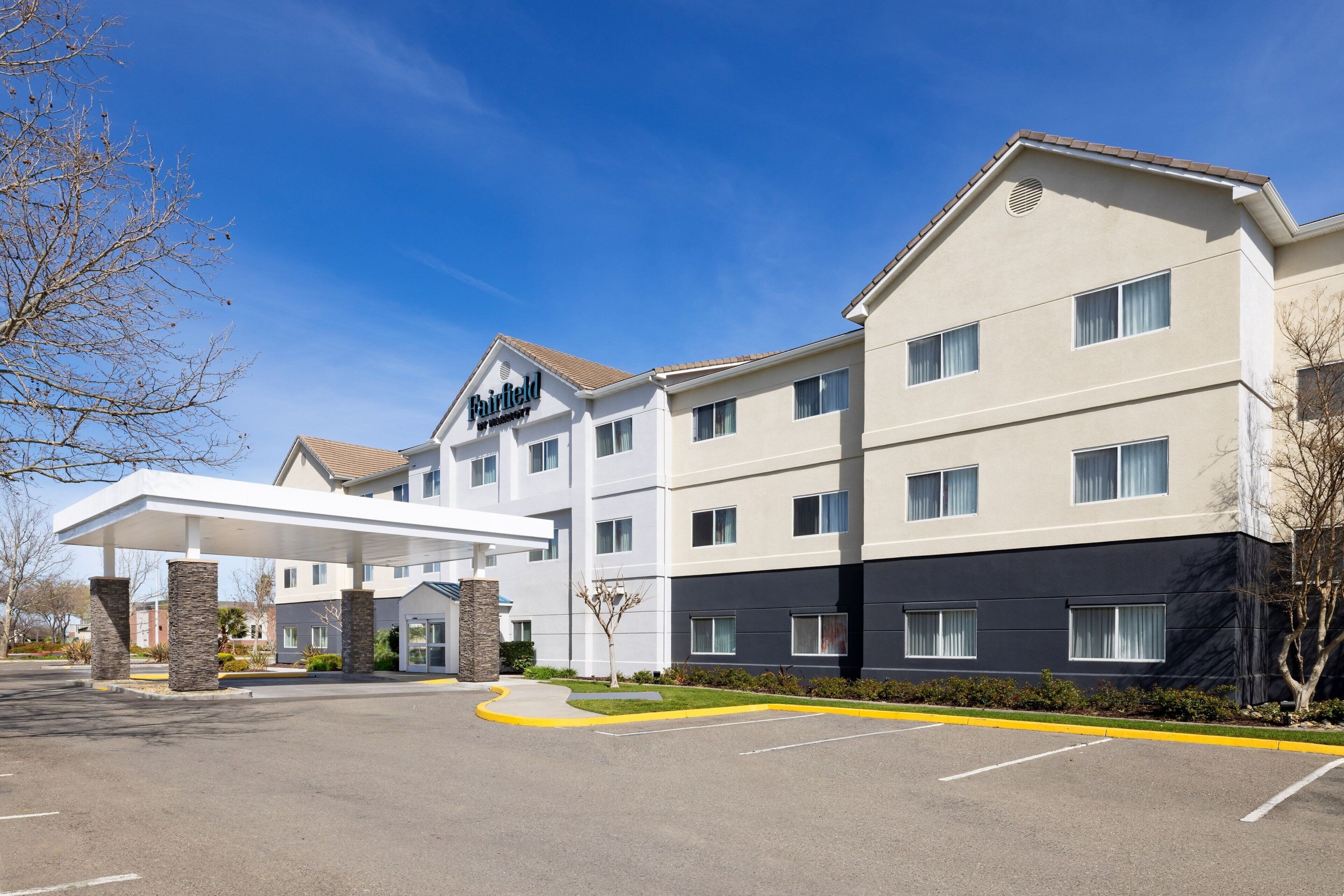 A Fairfield hotel with a covered parking area, multiple floors, and a modern architectural design.