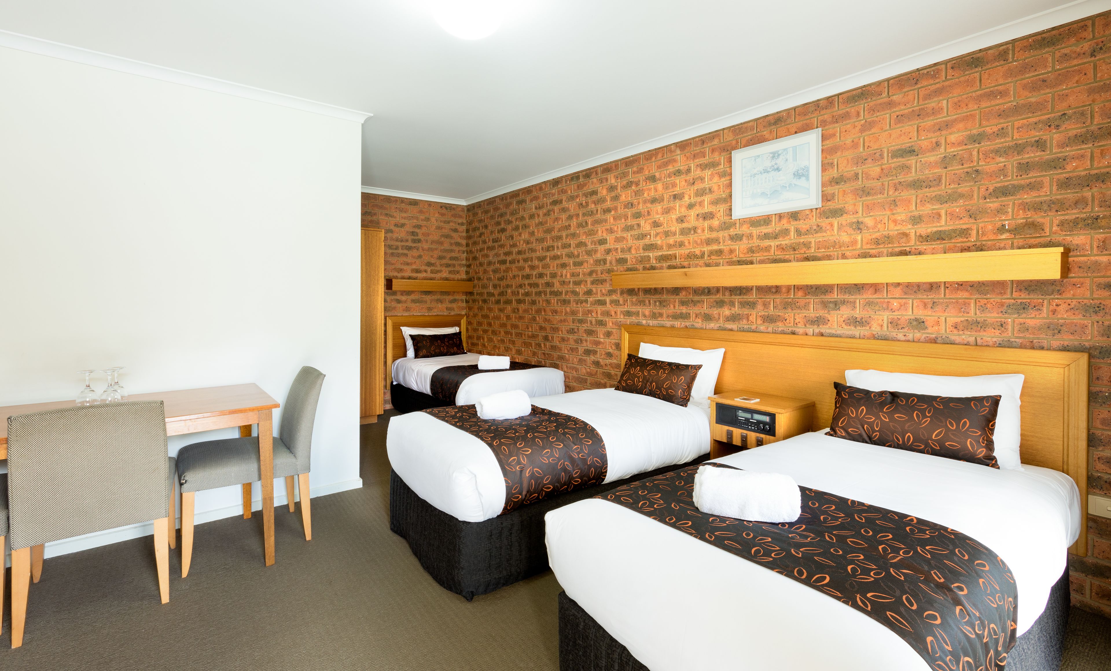 Ett hotellrum med två sängar, ett skrivbord och en stol.