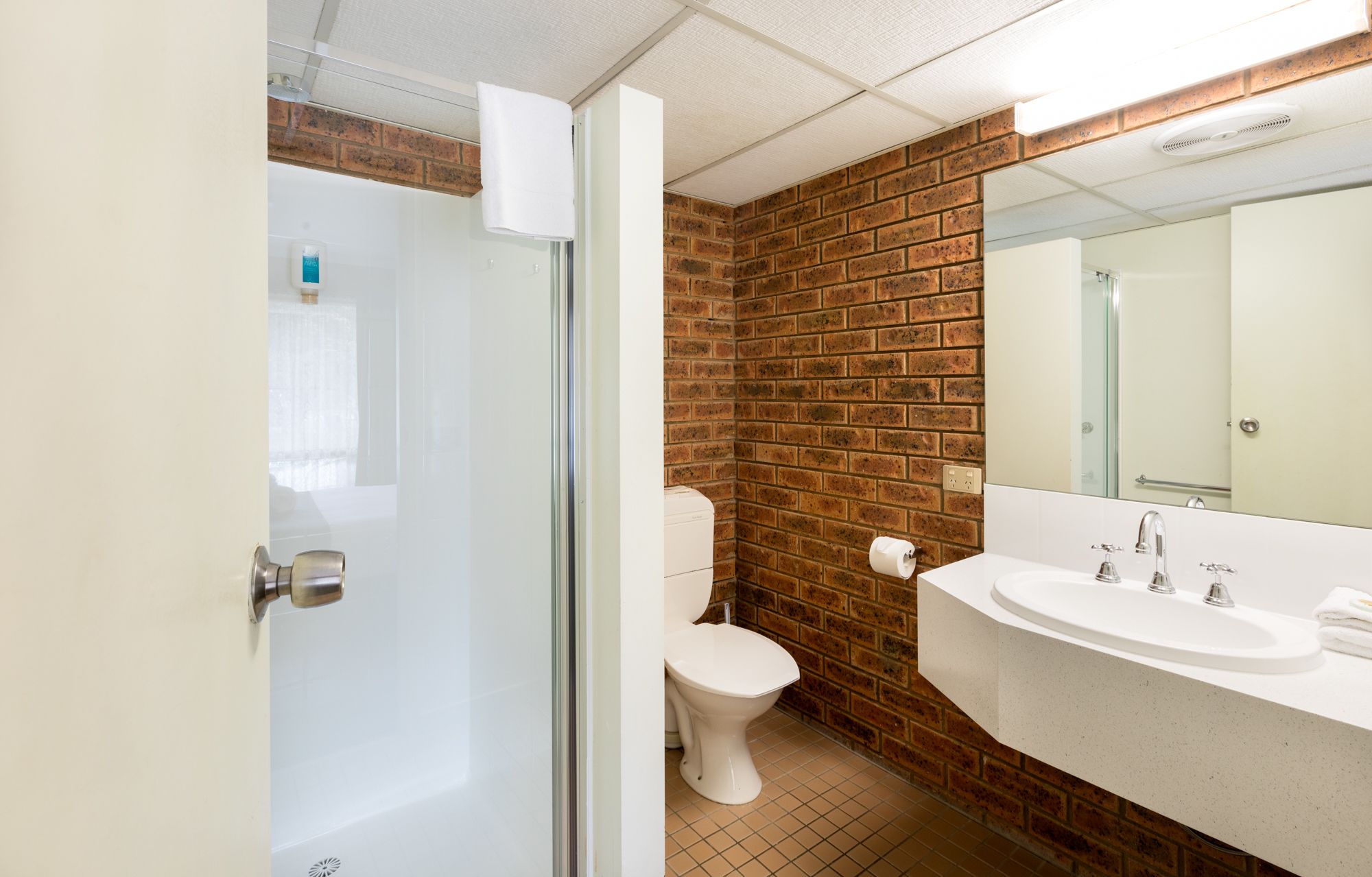Ein Badezimmer mit Toilette, Waschbecken und Spiegel.