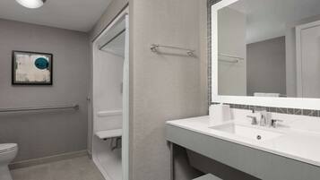 Un baño moderno con inodoro, lavamanos y ducha.